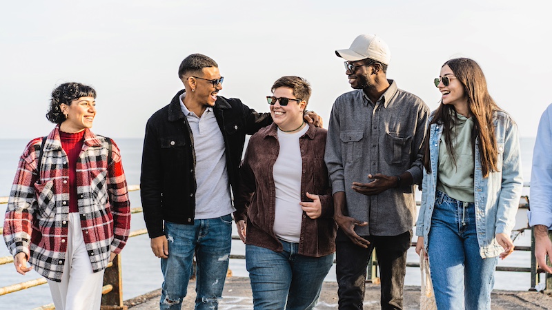 Diverse group of friends smiling talking and walking outdoors